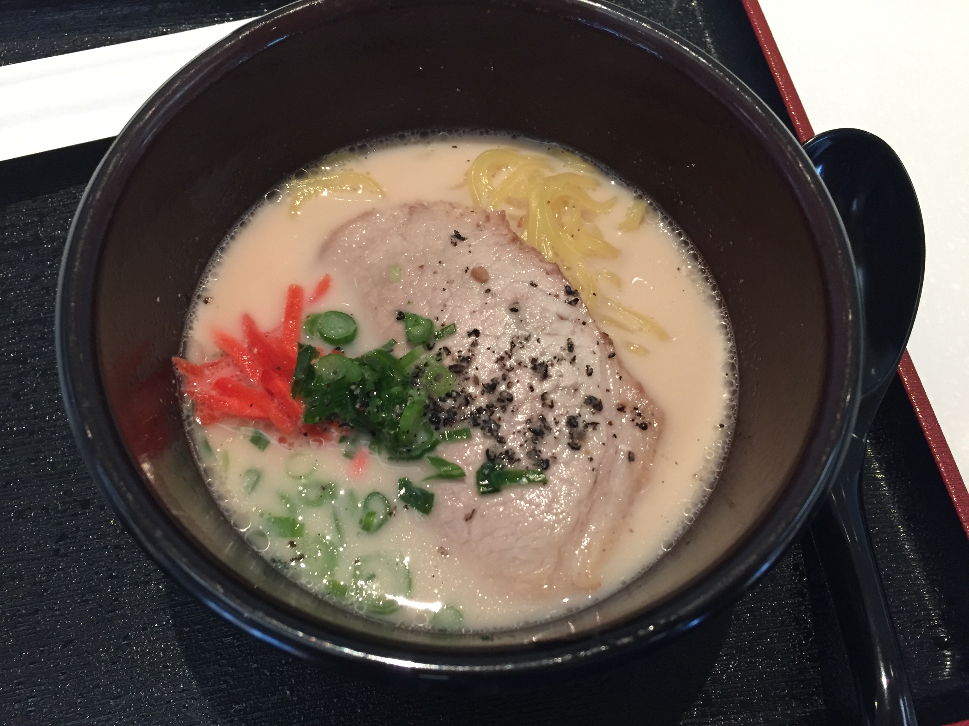 A bowl of tonkotsu ramen at the lounge — creamy broth, chashu, scallion, beni shoga