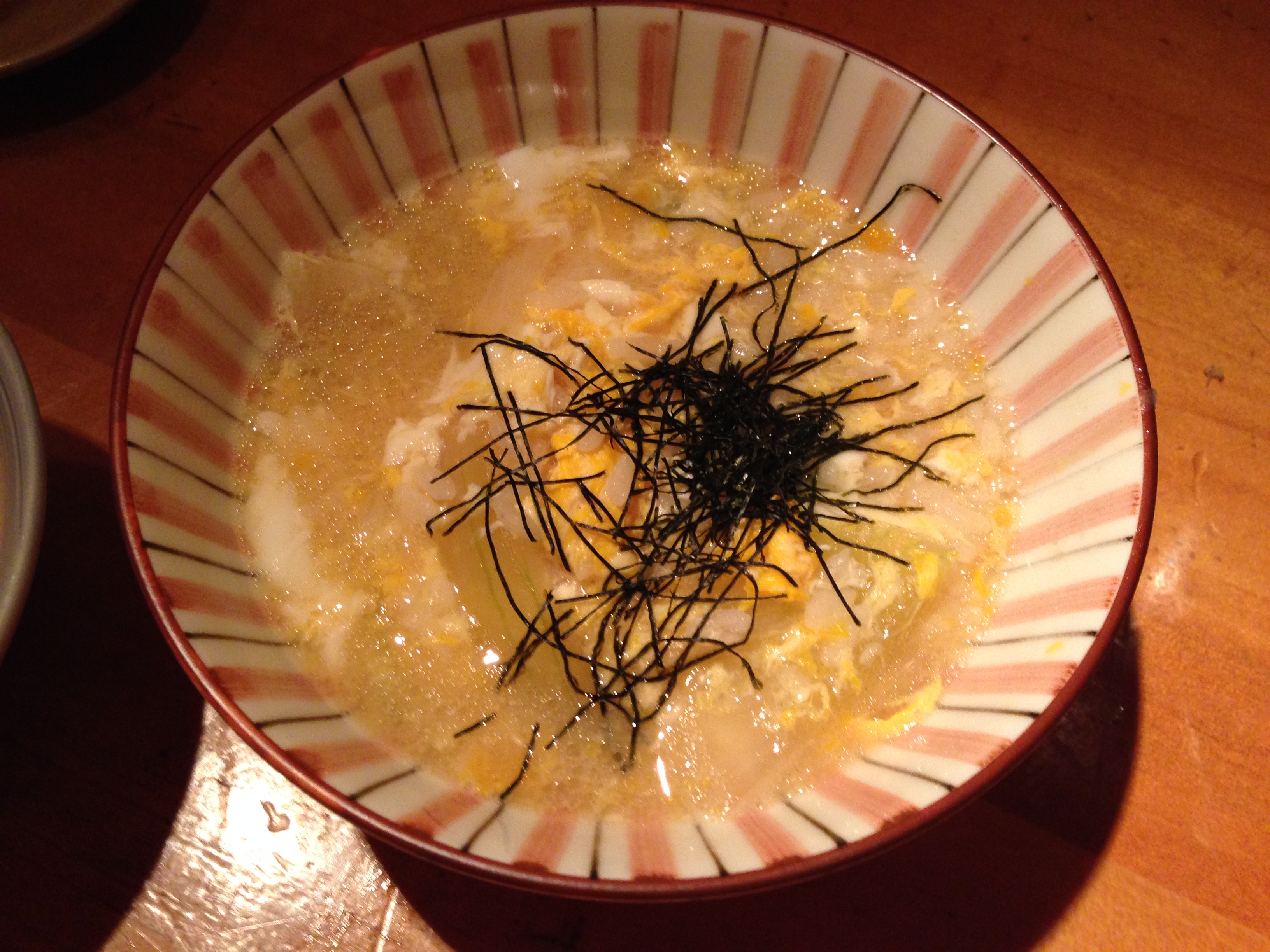 Rice in a striped bowl, bathed in dashi with shredded nori on top