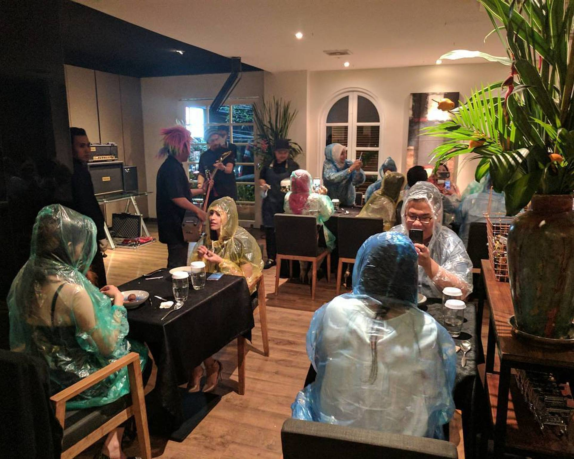 Diners wearing rain ponchos inside Namaaz Dining in Jakarta