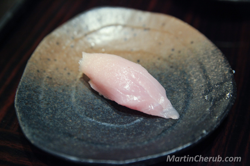 Albacore nigiri on a dark blue-grey plate