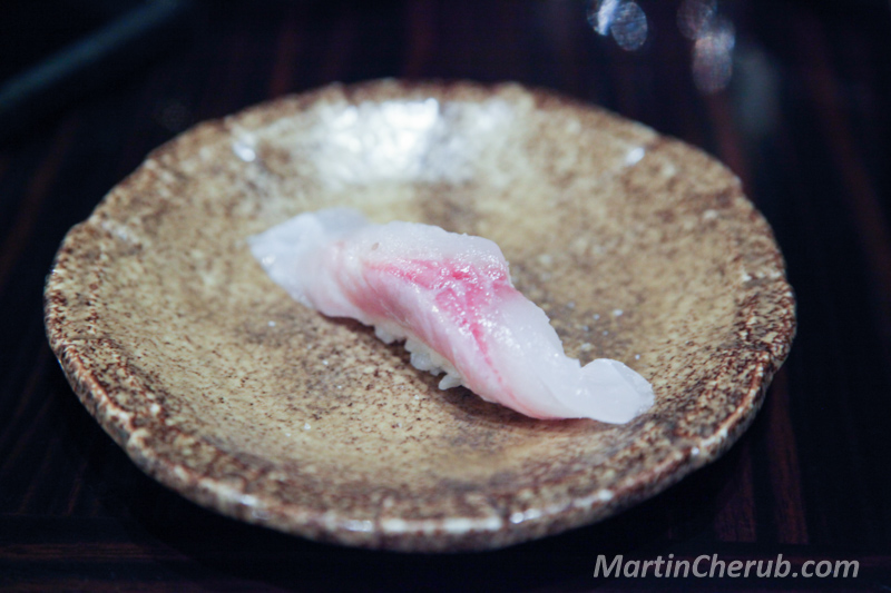 White fish nigiri on a brown speckled plate
